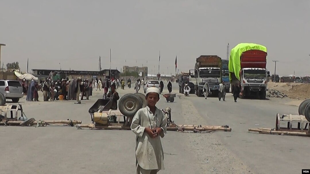FILE - A boy stands at the closed Chaman border crossing between Pakistan and Afghanistan with trucks seen stranded in the background.