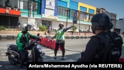 Polisi menghentikan sepeda motor di Solo, Jawa Tengah, 8 Juli 2021, saat pemberlakuan PPKM di Jawa dan Bali di tengah lonjakan kasus COVID-19. (Foto: Antara/Mohammad Ayudha via REUTERS)