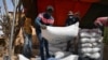 FILE - Workers carry the aid provided by the World Food Program (WFP) for distribution in Pissila, Burkina Faso, Jan. 24, 2020. 