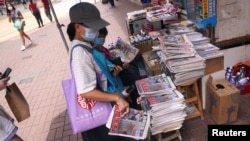 香港市民在街頭報攤上購買蘋果日報。（2020年8月11日）