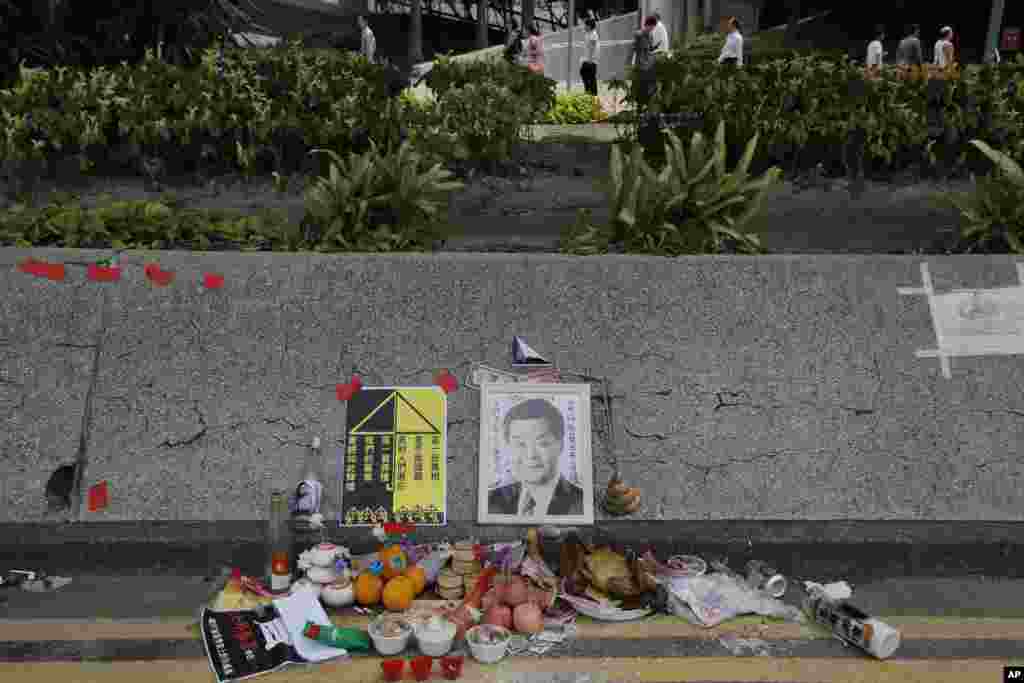 Offerings are placed in front of an altar set up by pro-democracy demonstrators to mark the symbolic death of Hong Kong Chief Executive Leung Chun-ying, near government headquarters in Hong Kong, Oct. 16, 2014.