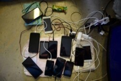 Cell phones sit to charge with the use of a generator, at a school which is without electricity and serving as a shelter for residents after a magnitude 6.4 earthquake in Ponce, Puerto Rico, Jan. 8, 2020.
