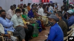 Indian's wait to receive vaccine for COVID-19 at a vaccination center in Mumbai, India, Sunday, April 18, 2021. Over 200,000 new infections were detected in the past 24 hours, and major cities, like Mumbai and New Delhi, are under virus restrictions…