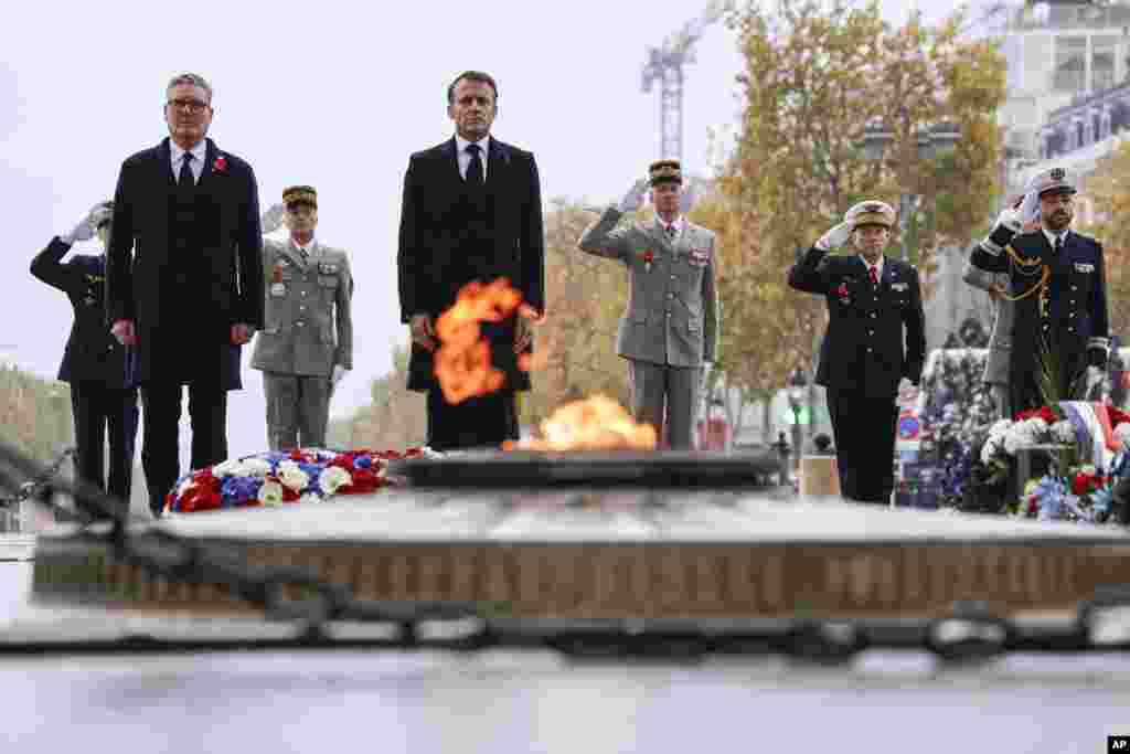 French President Emmanuel Macron, center, and Britain's Prime Minister Keir Starmer stand at attention at the Tomb of the Unknown Soldier during commemorations marking the 106th anniversary of the November 11, 1918, Armistice, ending World War I, in Paris.