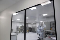 FILE - Laboratory technicians work at the mAbxience biopharmaceutical company on an experimental coronavirus vaccine developed by Oxford University and the laboratory AstraZeneca in Garin, Argentina, Aug. 14, 2020.