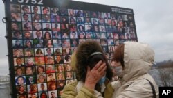 File - Relatives at a memorial in Kyiv, Ukraine, Jan. 8, 2021, for the victims of a Ukrainian 737-800 plane crash on the outskirts of Tehran one year after Iranian forces shot down the jetliner, killing all 176 people on board.