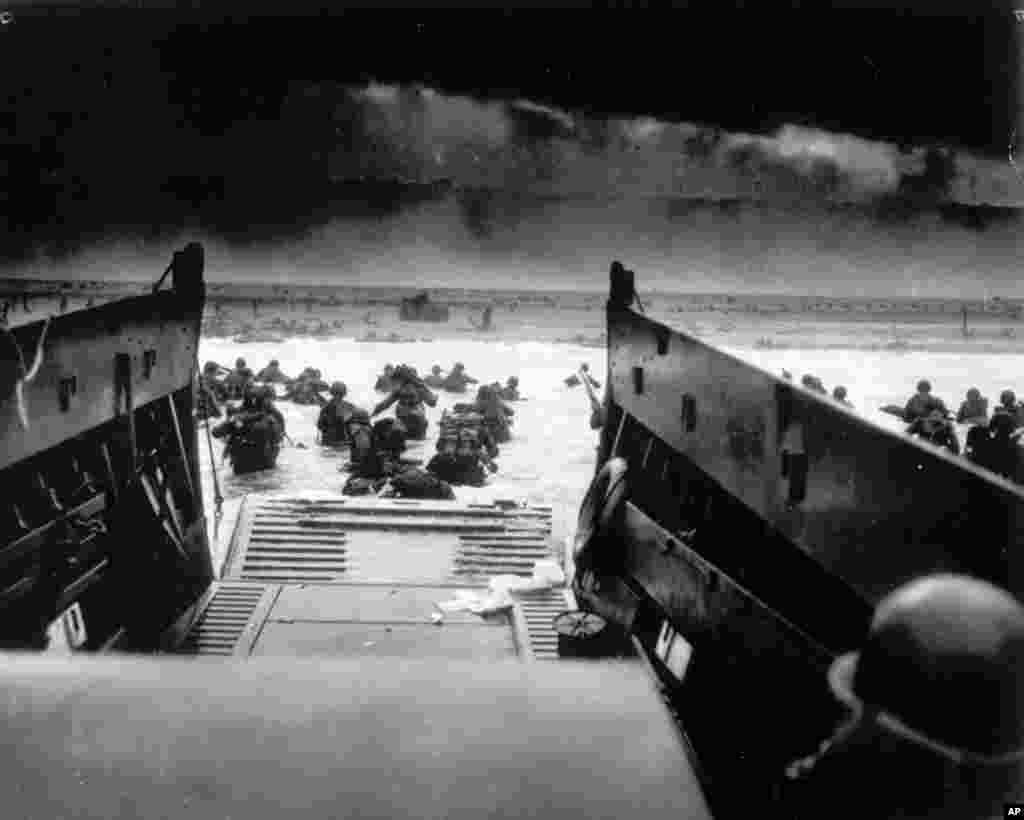 Saat diserang dengan tembakan senapan mesin dari penjaga pertahanan maritim Jerman, tentara Amerika turun dari kapal penjaga pantai AS dalam operasi pendaratan Sekutu di Normandia, Perancis, 6 Juni 1944.