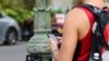 In this Oct. 25, 2017, photo, a man uses his cellphone before crossing a street in Honolulu. A new Honolulu ordinance allows police officers to issue tickets to pedestrians caught looking at a cellphone or electronic device while crossing a city street.