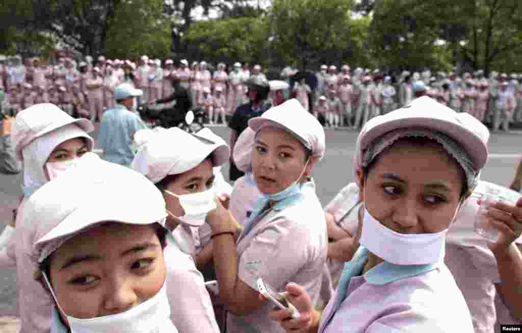 Pekerja perempuan berkumpul di depan sebuah pabrik selama demonstrasi di daerah industri Karawang, Jawa Barat. 