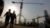 FILE - Workers walk out from a construction site at the Central Business District of Beijing, China, Jan. 20, 2015.
