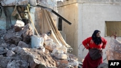 Žena stoji u ruševinama zgrade koja je, prema izveštajima, uništena u vazdušim udarima sirijskog saveznika Rusije, u gradu Kafranbel u pobunjenočkom delu pokrajine Idlib, 20. maja 2019.