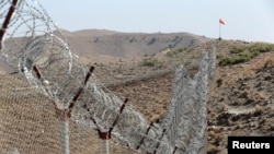 FILE - A view of the border fence outside the Kitton outpost on the border with Afghanistan in North Waziristan, Pakistan, Oct. 18, 2017. 