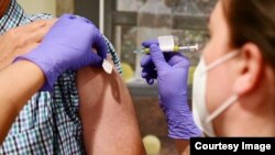 FILE - This undated file photo from Johnson & Johnson shows an experimental COVID-19 vaccine study undergoing late stage trials. The drug-maker announced Oct. 12 that it temporarily suspended the trials after an "unexplained illness." (Johnson & Johnson)