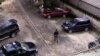 FILE - An unidentified policeman provides security inside the compound of a wealthy Nigerian man, with cars parked ready to provide armed convoys, and the compound protected by high walls and barbed wire in Port Harcourt, Nigeria, July 27, 2007. 