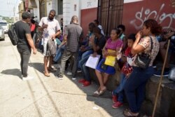 Migrants from Central America and Cuba line up outside the Mexican Commission for Refugee Assistance to apply for asylum and refugee status in Tapachula, Mexico, Sept. 13, 2019.