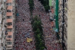 FILE - Protesters march during a rally against a controversial extradition law proposal in Hong Kong on June 9, 2019.