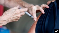 A man receives a COVID-19 vaccine at a clinic at Mother's Brewing Company in Springfield, Mo., on Tuesday, June 22, 2021.(Nathan Papes/The Springfield News-Leader via AP)