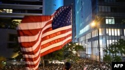 Seorang pedemo mengibarkan bendera AS dalam demonstrasi di Hong Kong, 14 Oktober 2019.