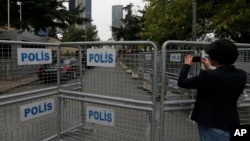 A journalist shoots video behind barriers blocking the road leading to Saudi Arabia's consulate in Istanbul, Turkey, Oct. 19, 2018. Saudi journalist Jamal Khashoggi entered the consulate on Oct. 2, 2018, and has not been seen since.