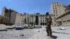 FILE - A Syria Democratic Forces (SDF) fighter walks in the silos and mills of Manbij after the SDF took control of it in Aleppo Governorate, Syria, July 1, 2016.