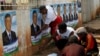 Supporters paste campaign posters of Madagascar's presidential candidate Robinson Jean-Louis along the streets of the capital, Antananarivo, October 23, 2013.
