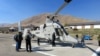 Federal firefighting managers peruse the “optionally piloted” K-MAX helicopter at the Lucky Peak Helibase in Idaho. (Credit: Tom Banse)