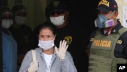 Mantan Capres Peru Keiko Fujimori, mengenakan masker untuk melindungi diri dari virus corona, melambaikan tangan kepada para wartawan saat dibebaskan dari penjara di Lima, Peru, 4 Mei 2020.