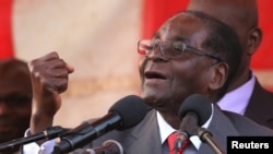 Zimbawe's president, Robert Mugabe, gestures as he addresses supporters of his ruling ZANU-PF party at Harare International Airport, Zimbabwe, Sept. 24, 2016. 