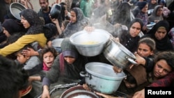 Warga Palestina antre untuk menerima bantuan makanan dari dapur amal sebelum gencatan senjata antara Hamas dan Israel mulai berlaku, di Khan Younis, di selatan Jalur Gaza, Jumat, 17 Januari 2025. (Foto: Hatem Khaled/Reuters)