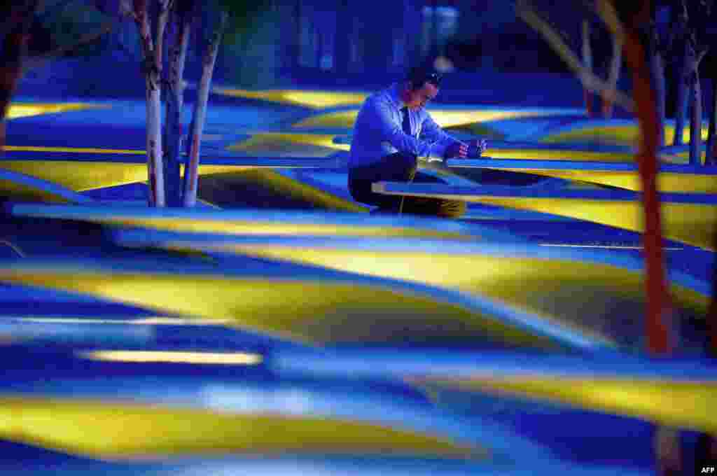 An unidentified man takes photos before sunrise at the National 9/11 Pentagon Memorial, Sept. 11, 2015, on the 14th anniversary of the 911 attacks.