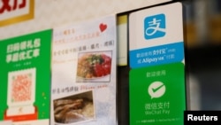 Logos for digital payment services Alipay by Ant Group, an affiliate of Alibaba Group Holding and WeChat Pay by Tencent Holdings are displayed outside a restaurant, in Hong Kong, China November 1, 2020. 