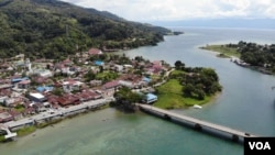 Aliran Sungai yang membela kota Tentena, dengan latar gunung dan danau Poso di kejauhan. (Foto: VOA/Yoanes) 