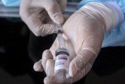 Seorang nakes mempersiapkan vaksin COVID-19 produksi AstraZeneca di Sidoarjo, dekat Surabaya. (Foto: Thomson/REUTERS).