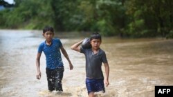 ဟာရီကိန်း Eta ကြောင့် ရေလွှမ်းသွားတဲ့ ဂွာတီမာလာမြို့တနေရာမှာ ကလေးငယ်များ ရေထဲဖြတ်သွားနေကြစဉ် (Photo by Johan ORDONEZ / AFP)