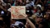 A student holds a placard during their protest against university tuition hikes outside the ruling party African National Congress (ANC) headquarters in Johannesburg, South Africa, Thursday, Oct. 22, 2015. 
