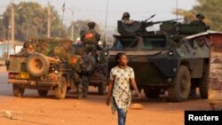 Seorang perempuan berjalan melewati tentara penjaga perdamaian Perancis di Bangui, Republik Afrika Tengah (17/1)/
