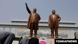 북한 주민들이 평양 만수대의 김일성·김정일 부자의 동상에 절하고 있다. (자료사진)