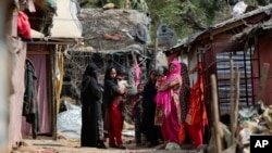 Para pengungsi Rohingya berdiri di luar kamp darurat di pinggiran Jammu, India, 7 Maret 2021.