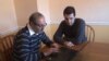Taofik Alhallak, who fled Syria with his wife in 2012, checks the blog he created to document the crisis in his homeland. The couple are seeking asylum and, with son Urwa Alhallak, have recently settled in northern Virginia. (J. Swicord/VOA)