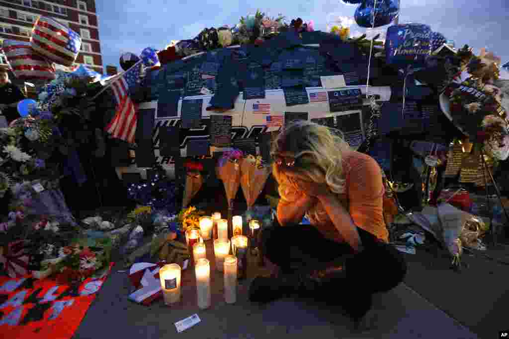 Tasha Lomoglio, of Dallas, cries after lighting candles at a makeshift memorial in honor of the slain Dallas police officers in front of police headquarters in Dallas, Texas, July 9, 2016.