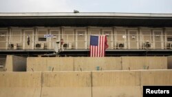 FILE - A U.S. flag hangs on a housing unit inside of Bagram Airfield in the Parwan province of Afghanistan, Jan. 2, 2015. According to numbers provided late last year by the outgoing Obama administration, the U.S. is maintaining approximately 8,400 troops in Afghanistan.