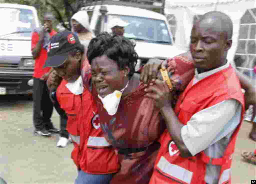 Red Cross personnel console a woman after she viewed the body of a relative killed in last week's attack at a university in Garissa, northeastern Kenya, at Chiromo funeral home, Nairobi, April 7, 2015.