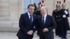 Kancelari gjerman Olaf Scholz shtrëngon duart me Presidentin francez Emmanuel Macron para takimit të udhëheqësve kryesor evropianë në Paris mbi Ukrainën