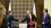 Russian President Vladimir Putin shakes hands with Prime Minister Dmitry Medvedev during a Security Council meeting in Sochi March 13, 2014