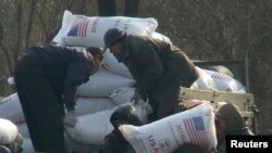지난 2008년 12월 북한 신의주 주민들이 미국에서 지원한 식량을 트럭에서 내리고 있다. 식량 자루에 'USAID(미국제개발처)' '미국에서 보내온 선물' 이란 문구가 씌여있다. (자료사진)