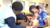 Malnutrition can stunt children's growth or fuel excess weight. Here, a health care worker assesses a child at a clinic in Nairobi, Kenya. See related video by VOA's Lenny Ruvaga.