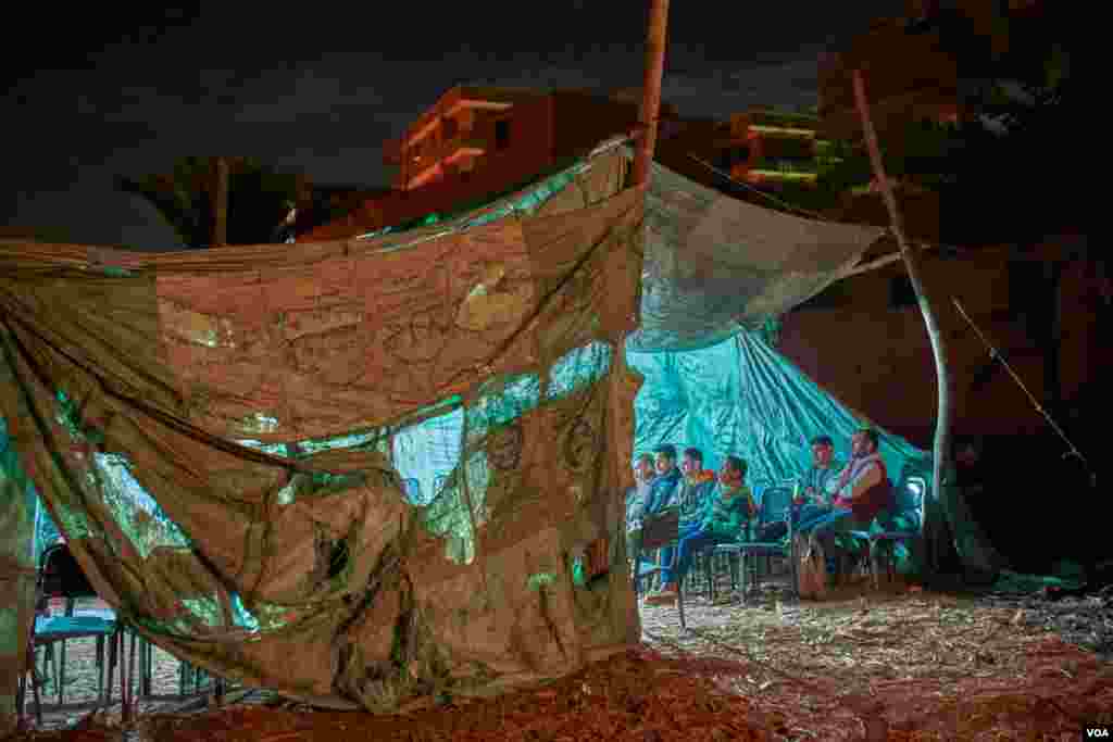 On a remote patch of barren land in the farming village of Tattay in Tanta, Egypt, bettors gather in a makeshift tent for Indian rooster fights each Thursday night. Betting and animal fights are illegal in Egypt. (H. Elrasam/VOA)
