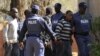 Police keep watch during the arrival of some of the 250 mine workers who were arrested when they had a shoot out with police, at a Garankuwa court outside Pretoria, South Africa, August 20, 2012. 