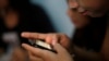 A teenage sex worker checks messages on her mobile phone at a boarding house in Bandung, West Java, Indonesia, Aug. 1, 2013.