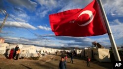 FILE - A Turkish flag flies at the refugee camp for Syrian refugees in Islahiye, Gaziantep province, southeastern Turkey, March 16, 2016. Merkel plans to visit the camp during her stay in Turkey.